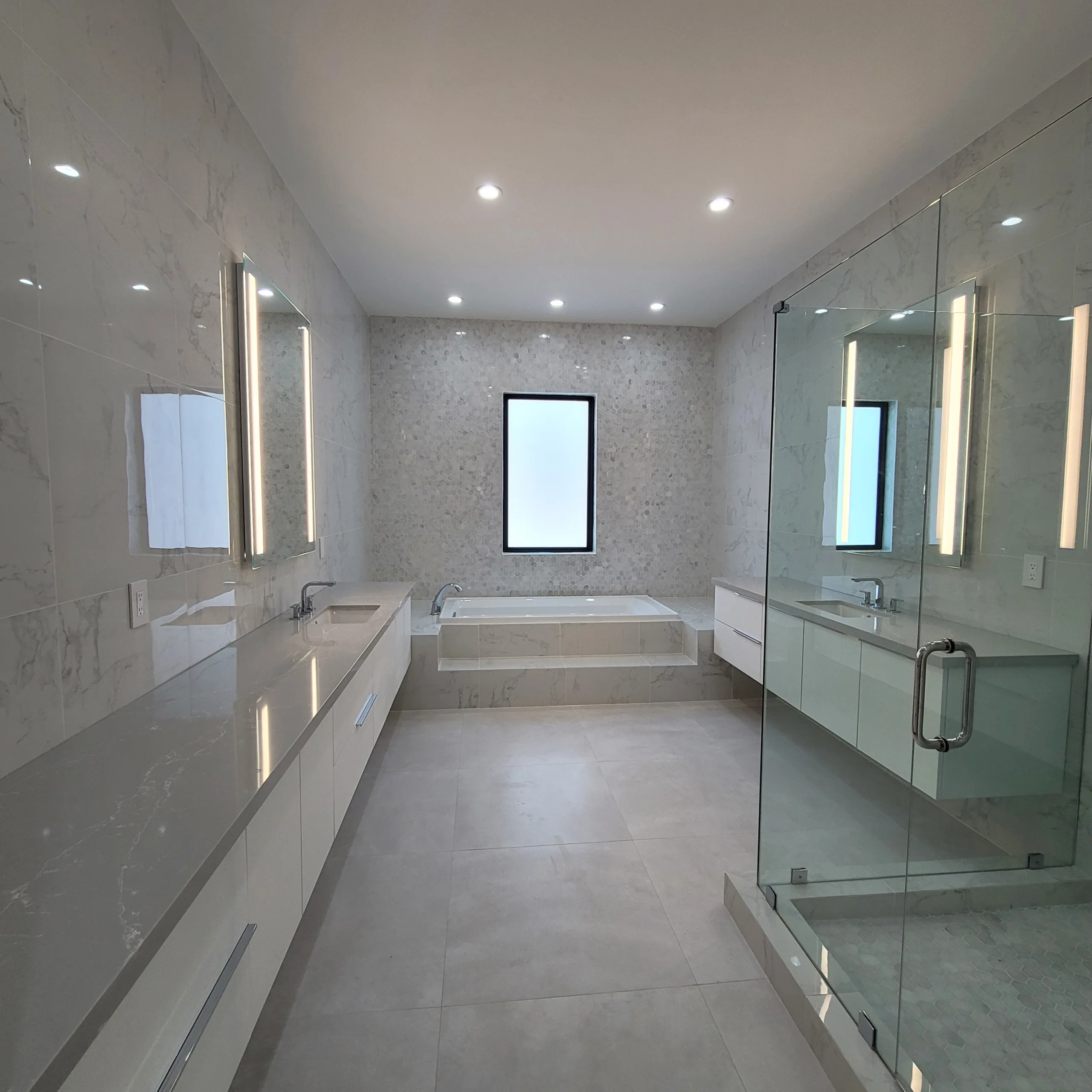 Light-veined Neolith stone master bathroom with dual vanities in a Key Biscayne home